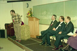 Rick Mawson (Theatre dept staffer) presenting. Principal Barry Moore, Chilliwack Mayr John Jansen, and MP Ross Belsher observe.